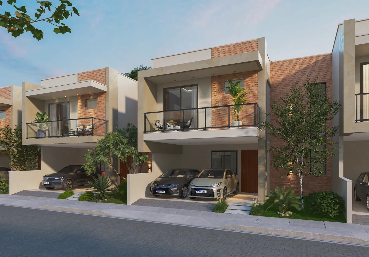 Fachadas das casas do Tree Residence ao entardecer, com varandas, tijolinho aparente e jardins na frente